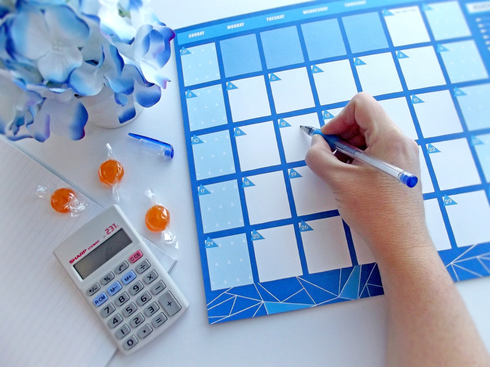 person writing on a blank calendar