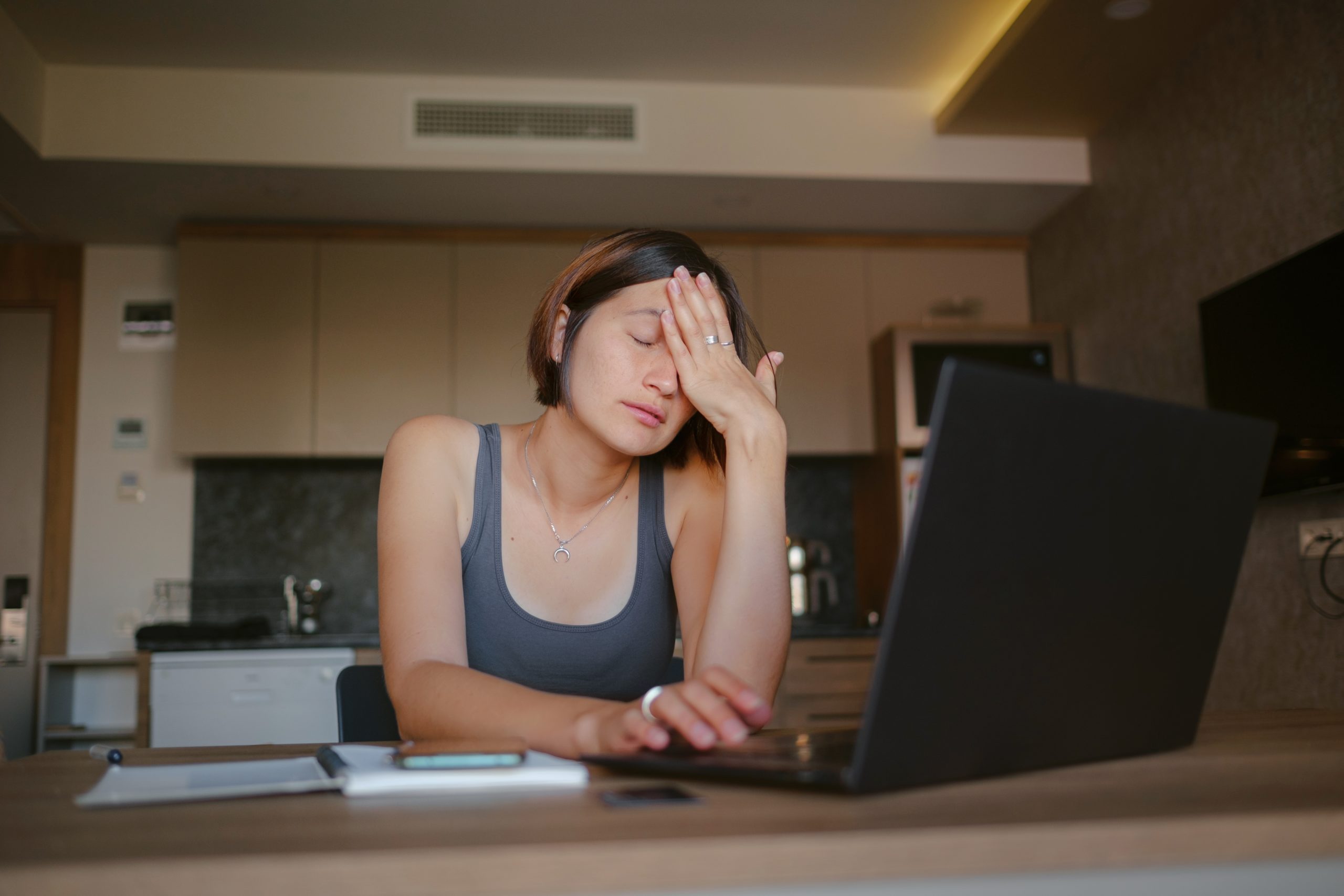 Frustrated sad woman feeling tired, worried about problem sitting at laptop, depressed girl worried about reading bad news online, debt notification email or negative message