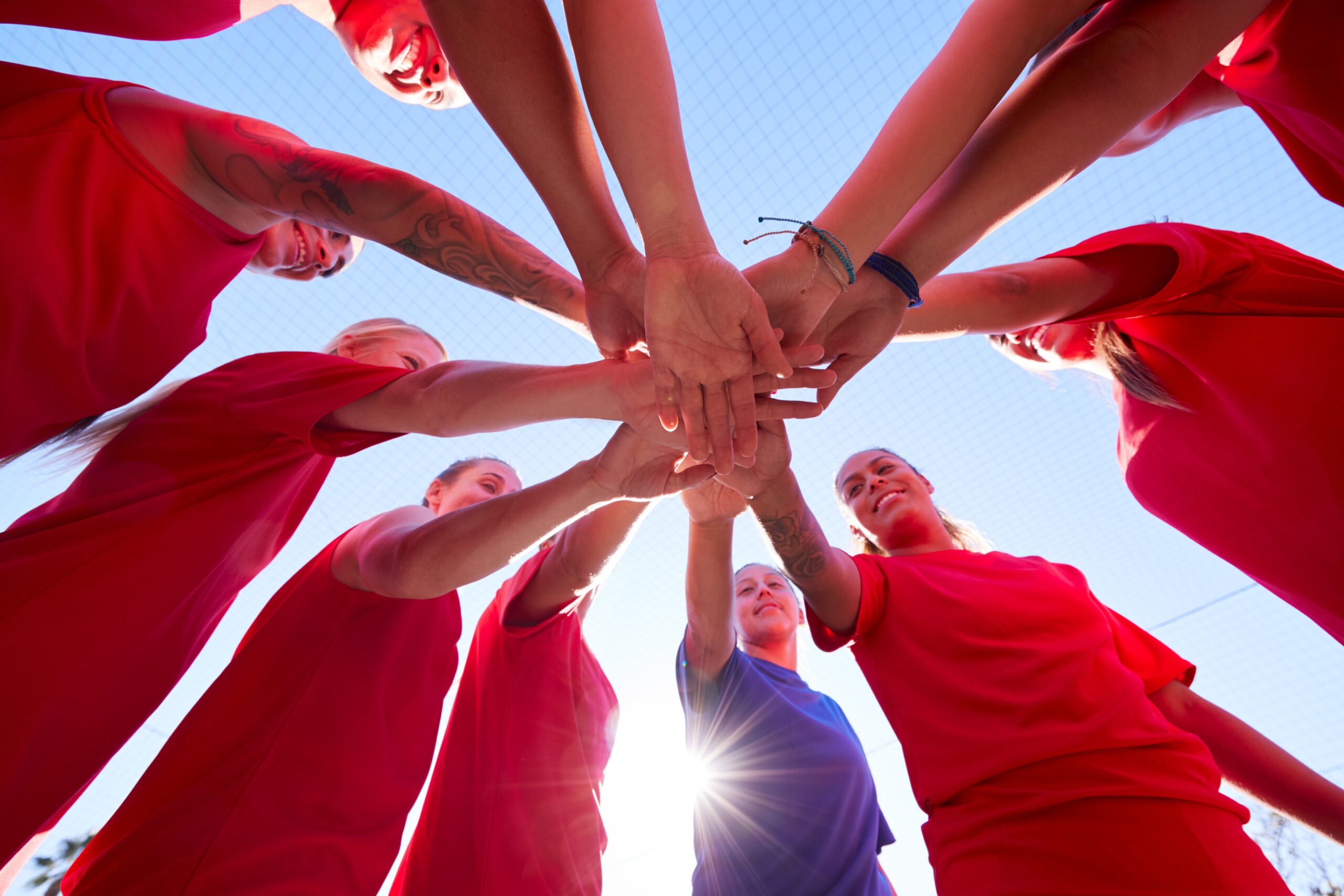 group of women joining hands - communications director pep talk metaphor