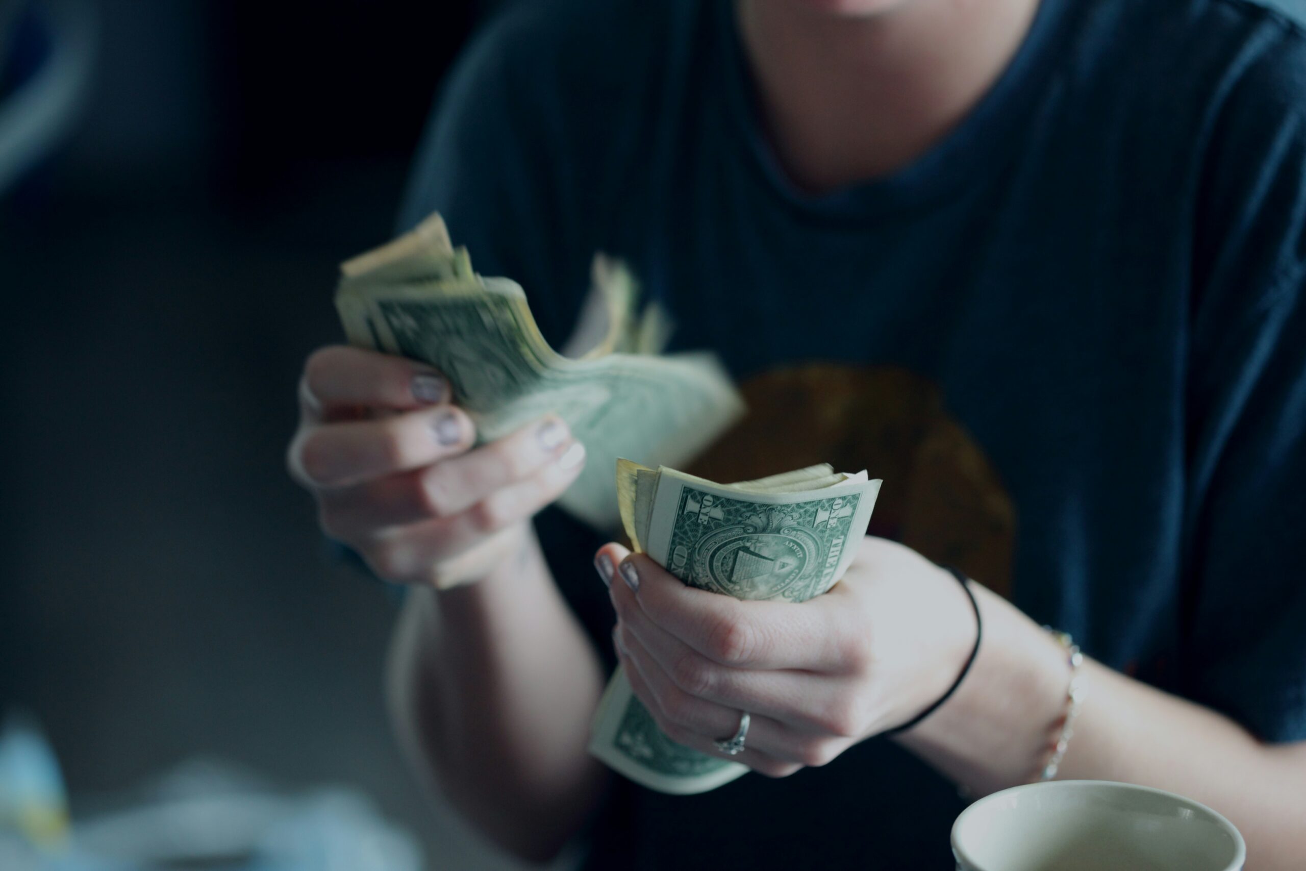 woman counting cash with two hands