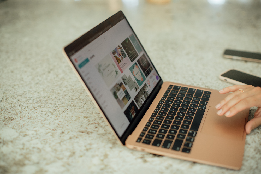 Person using Canva on laptop on a counter.png from canva
