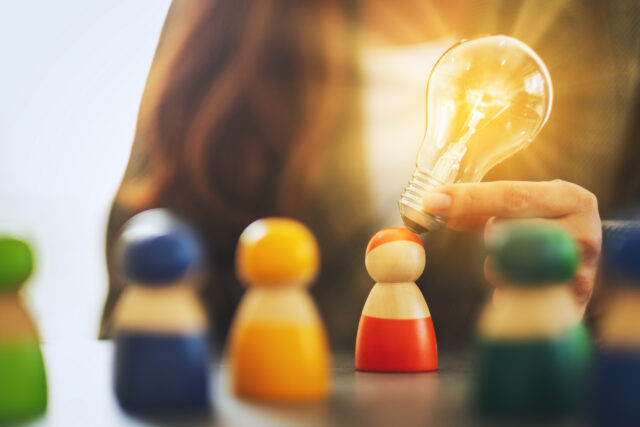Closeup image of a woman holding and putting a light bulb over o